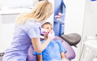 Una dentista atiende a un niño en consulta.