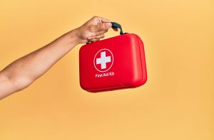 Mano sosteniendo botiquín de emergencias. 