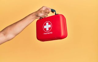 Mano sosteniendo botiquín de emergencias.