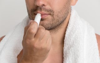 Hombre aplicándose protector labial.
