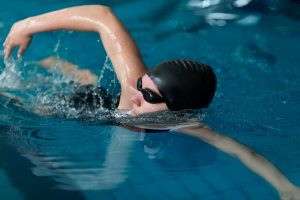 Persona practicando natación en piscina.
