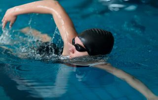 Persona practicando natación en piscina.